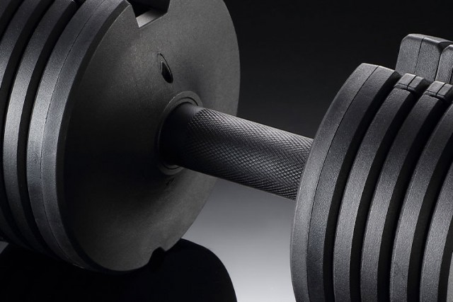 Close-up of the handle of 25lb black adjustable dumbbell showing the textured grip