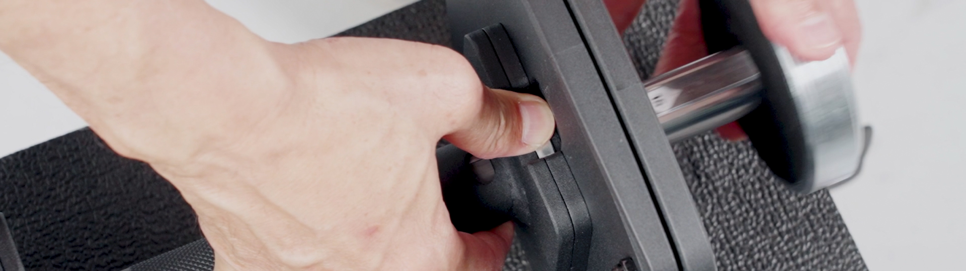 Two 100lb black adjustable dumbbells on a workout bench.