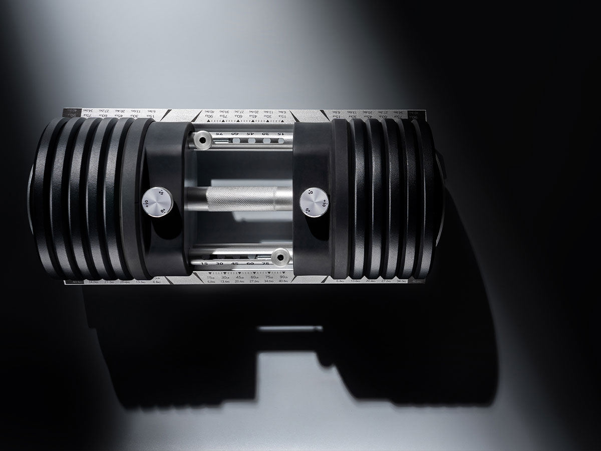 Top view of a 100lb black adjustable dumbbell with weights.