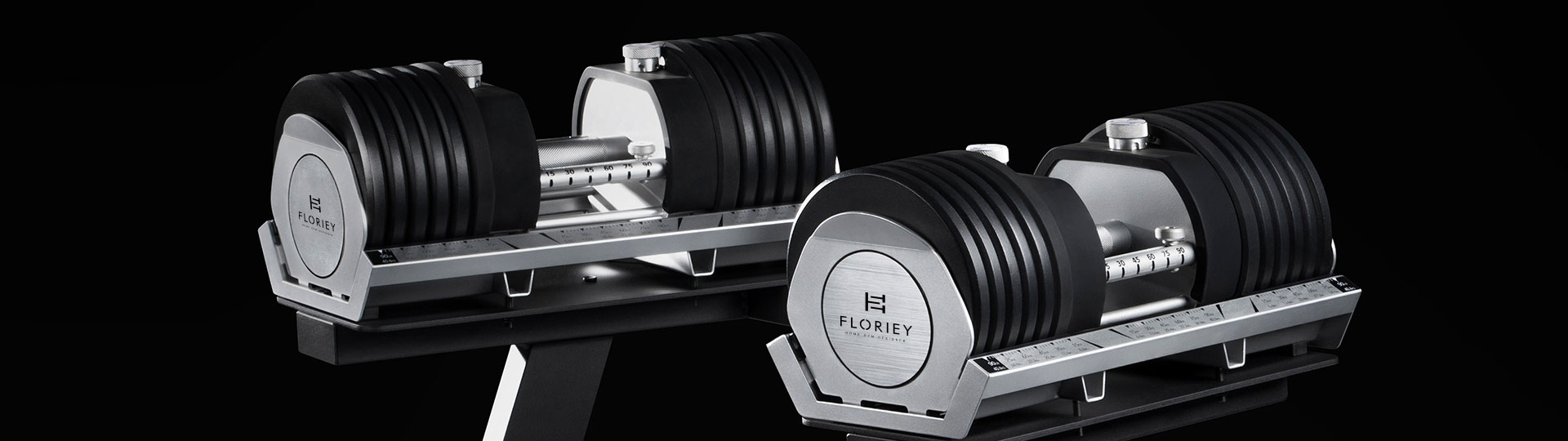 Two 100lb black adjustable dumbbells on a workout bench.