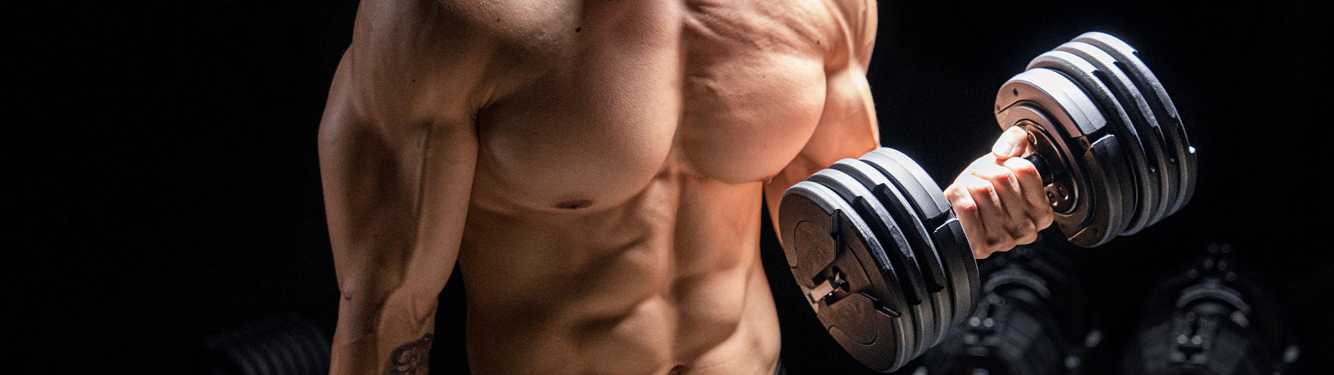 Man lifting a 75lb adjustable dumbbell in a home gym setup