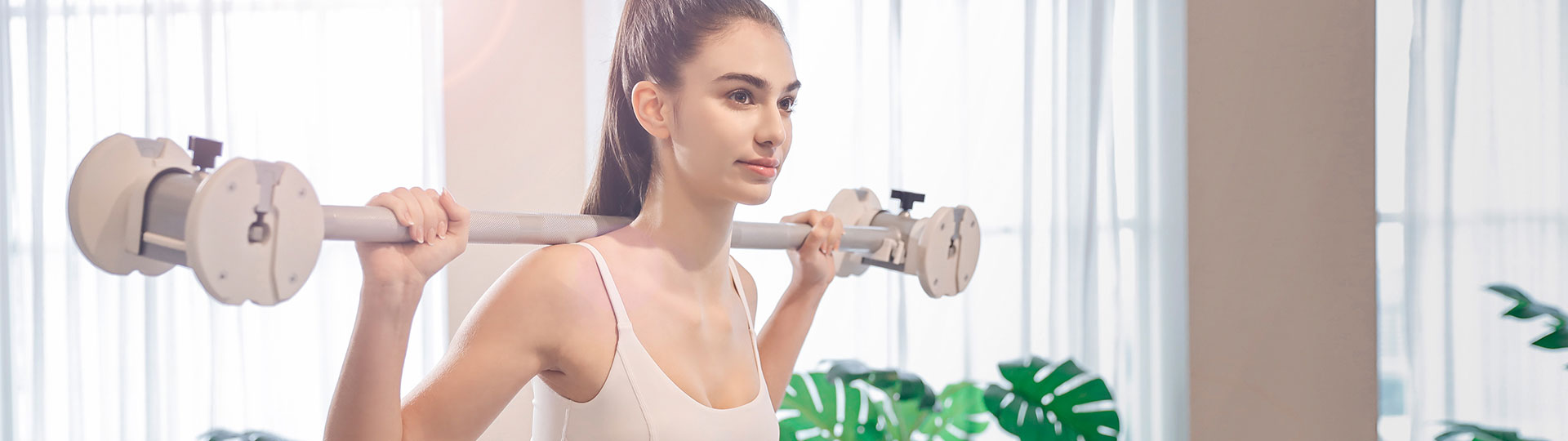 Woman performing shoulder exercises with white adjustable dumbbell set