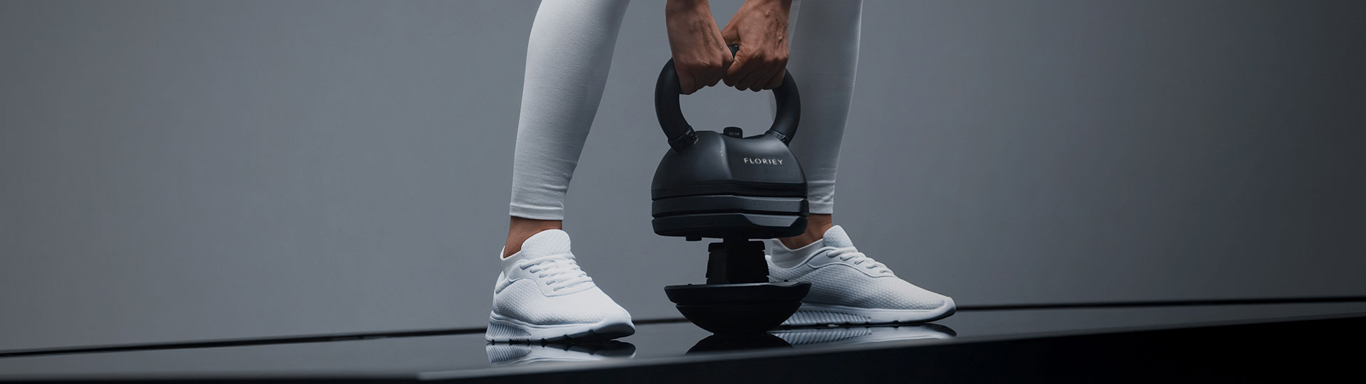 Person using 30lb black adjustable kettlebell during workout